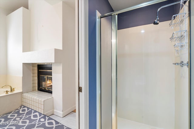 bathroom featuring tile patterned floors, a tile fireplace, and independent shower and bath