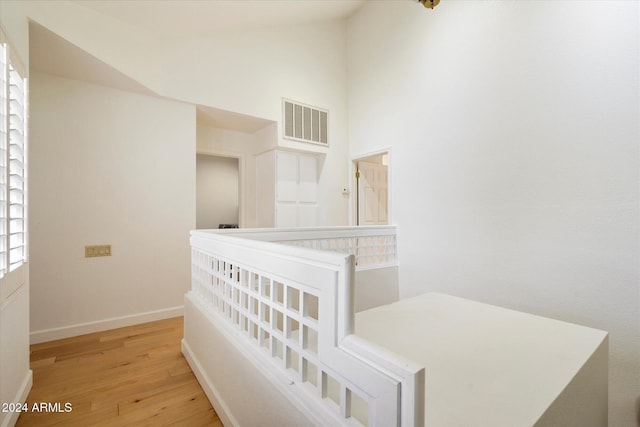 corridor featuring vaulted ceiling and light hardwood / wood-style flooring