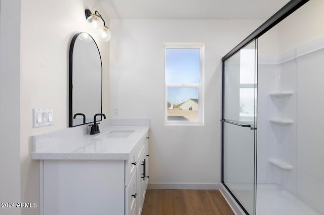 bathroom featuring a shower with door, vanity, and wood-type flooring