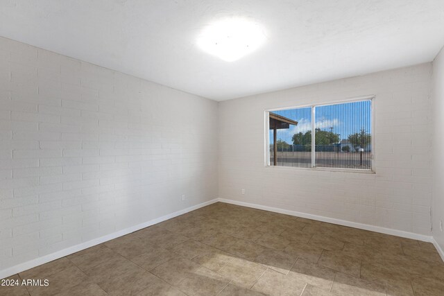 unfurnished room with brick wall