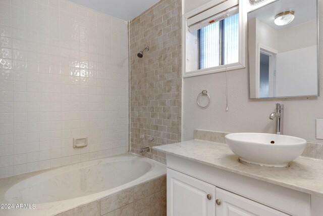 bathroom with tiled shower / bath and vanity