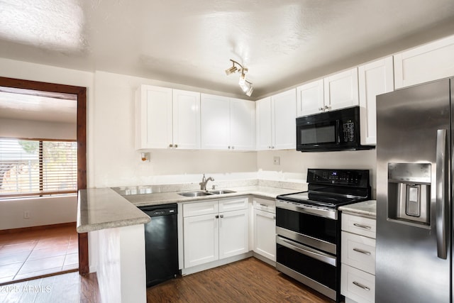 kitchen with white cabinetry, black appliances, and a sink