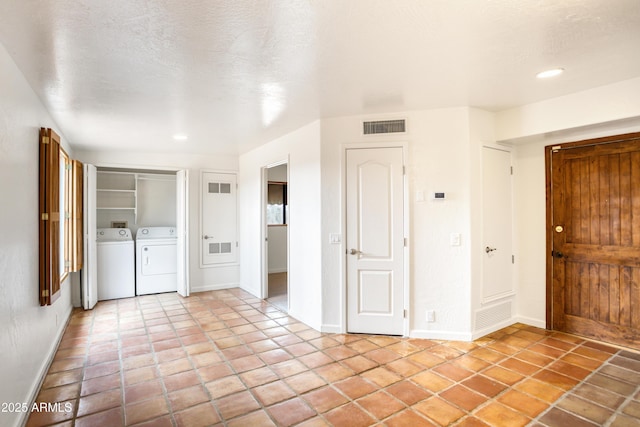 interior space with baseboards, independent washer and dryer, visible vents, and light tile patterned floors