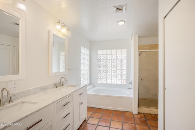 bathroom with a bath, visible vents, a shower stall, and a sink