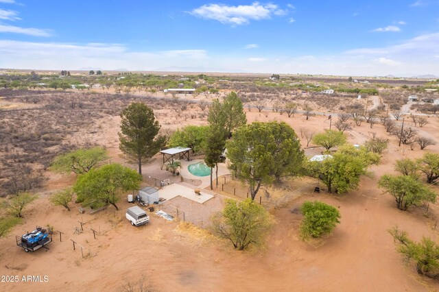drone / aerial view featuring a rural view, a desert view, and a mountain view