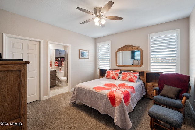 carpeted bedroom featuring ceiling fan and ensuite bath