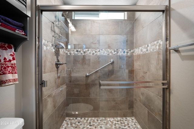 bathroom with an enclosed shower and toilet