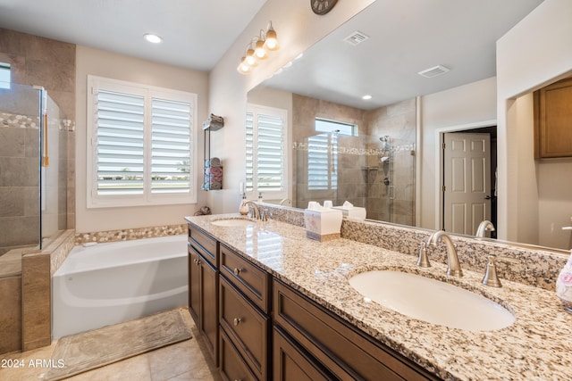 bathroom featuring a wealth of natural light, double vanity, and plus walk in shower