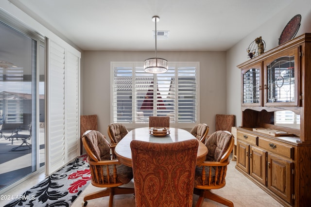 tiled dining space with an inviting chandelier