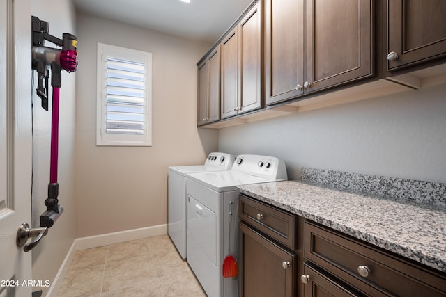 laundry area with cabinets, separate washer and dryer, and light tile floors