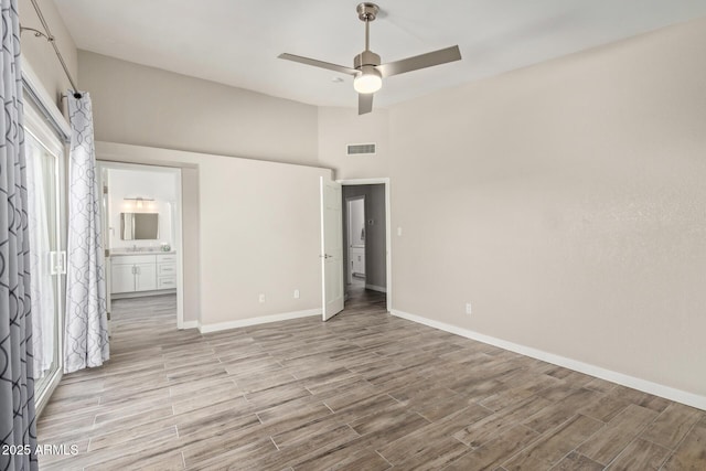 unfurnished bedroom featuring visible vents, connected bathroom, baseboards, ceiling fan, and light wood-style flooring