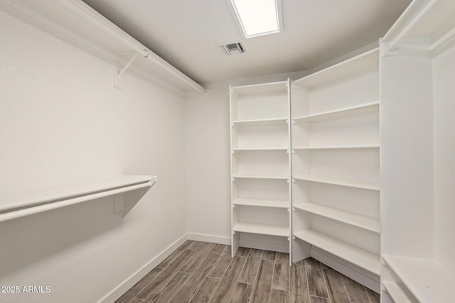 walk in closet with visible vents and wood finished floors