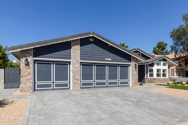 view of front facade with a garage, brick siding, and driveway