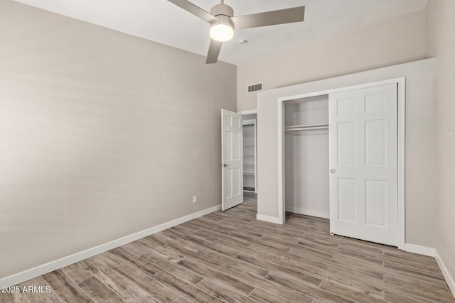 unfurnished bedroom featuring visible vents, baseboards, a closet, and light wood-style flooring