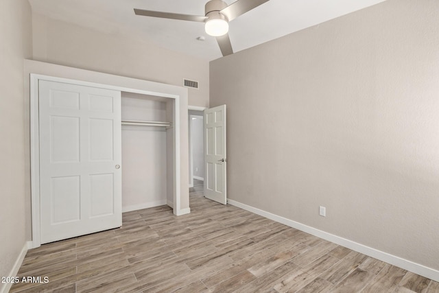 unfurnished bedroom featuring a closet, visible vents, baseboards, and wood finished floors