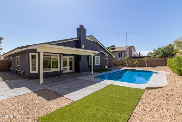 view of pool featuring a patio, french doors, a fenced in pool, and a fenced backyard