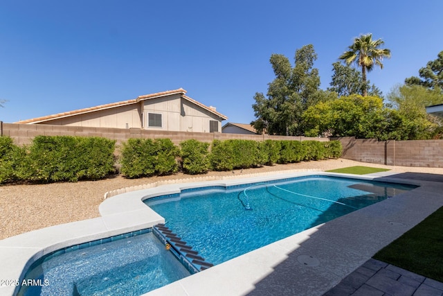 view of pool with a pool with connected hot tub and a fenced backyard