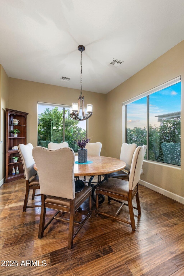 dining room featuring a wealth of natural light, visible vents, a notable chandelier, and baseboards