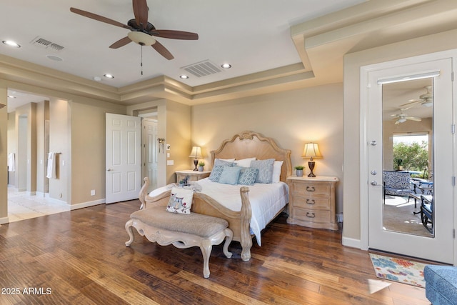 bedroom featuring a raised ceiling, visible vents, and wood finished floors