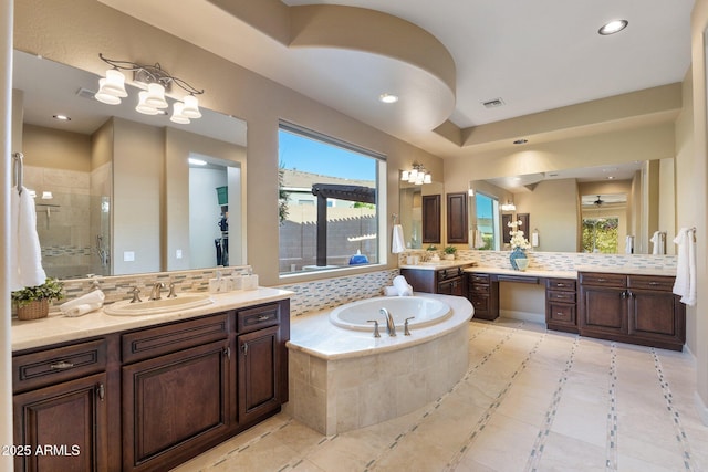bathroom with a sink, visible vents, a stall shower, a bath, and a wealth of natural light
