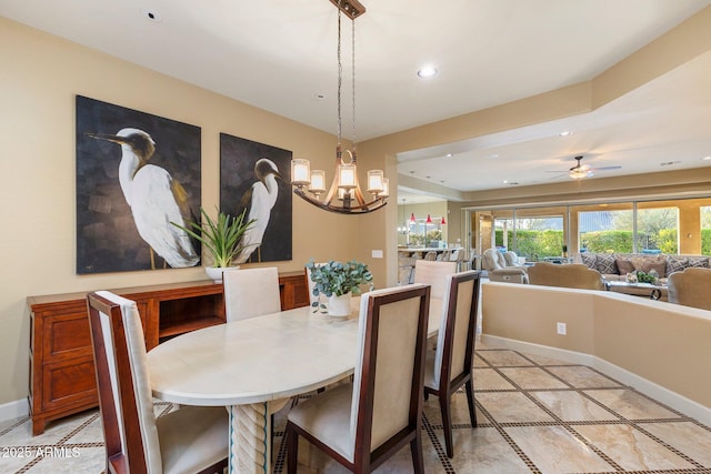 dining area with light tile patterned floors, recessed lighting, ceiling fan with notable chandelier, and baseboards