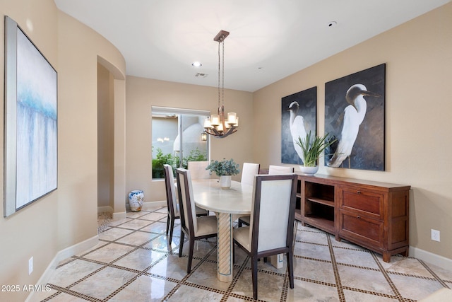 dining area with light tile patterned floors, a chandelier, arched walkways, baseboards, and recessed lighting