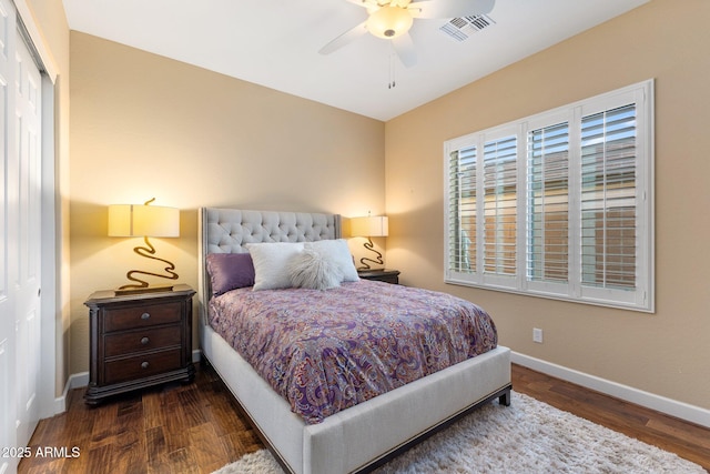 bedroom with wood finished floors, ceiling fan, visible vents, and baseboards