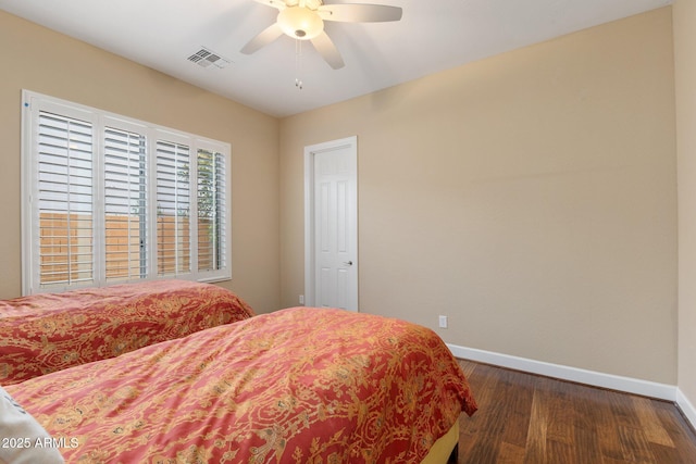bedroom with dark wood-type flooring, a ceiling fan, visible vents, and baseboards