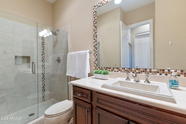 full bath featuring toilet, a shower stall, and vanity