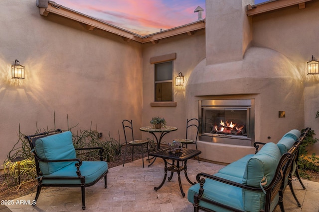 view of patio / terrace featuring a lit fireplace