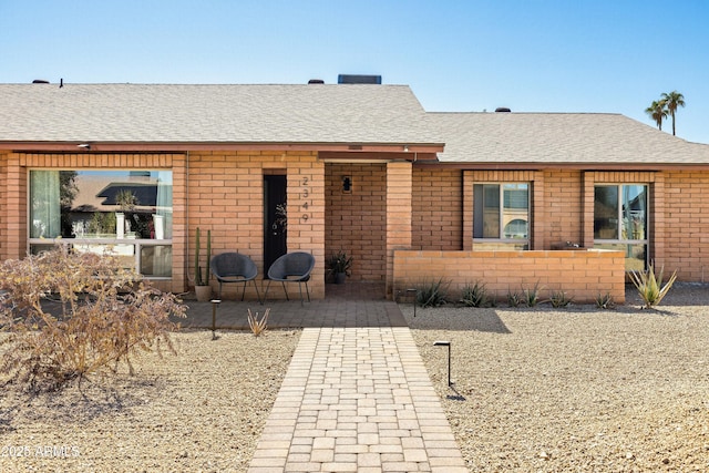 single story home with brick siding and roof with shingles