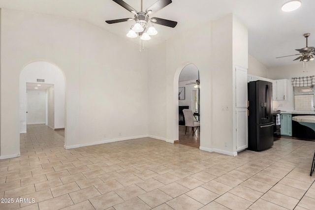 living room featuring arched walkways, high vaulted ceiling, and a ceiling fan