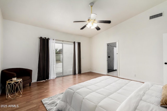 bedroom featuring visible vents, baseboards, vaulted ceiling, wood finished floors, and access to outside