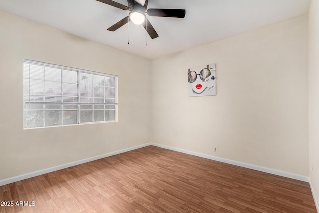 unfurnished room featuring baseboards, wood finished floors, and a ceiling fan