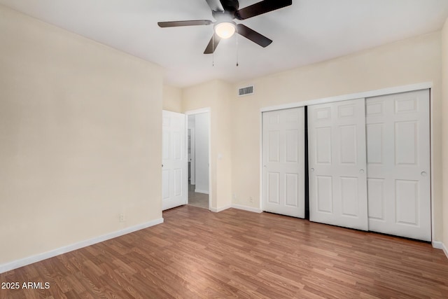 unfurnished bedroom with light wood finished floors, visible vents, baseboards, a closet, and a ceiling fan