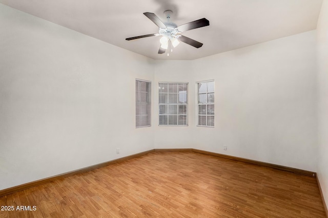 empty room featuring light wood-type flooring, baseboards, visible vents, and ceiling fan