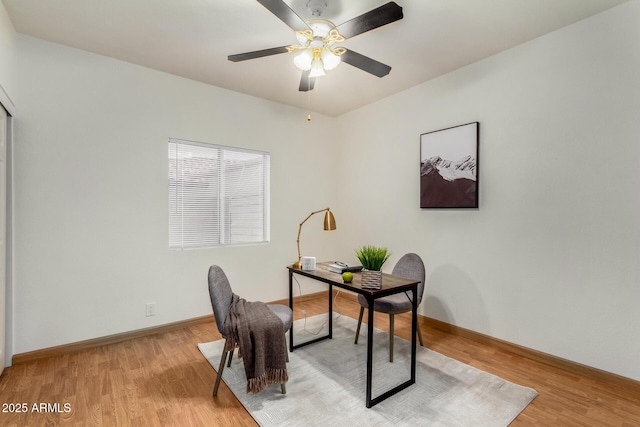 office space featuring a ceiling fan, light wood-type flooring, and baseboards