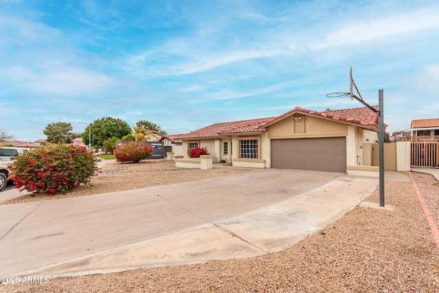 view of front of house with concrete driveway, a tiled roof, an attached garage, and stucco siding