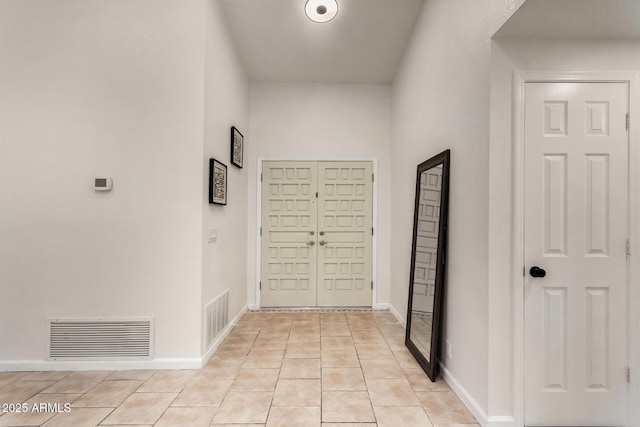 entryway featuring light tile patterned floors, baseboards, and visible vents