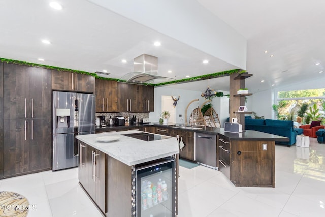 kitchen featuring island range hood, stainless steel appliances, wine cooler, and a center island