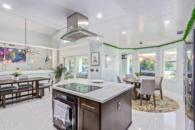 kitchen with decorative light fixtures, oven, island exhaust hood, plenty of natural light, and black electric cooktop