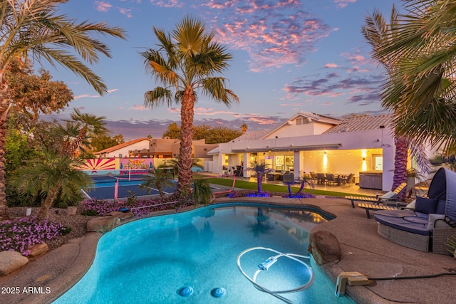 view of pool at dusk