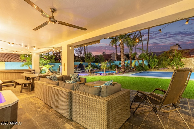 patio terrace at dusk featuring outdoor lounge area and a hot tub