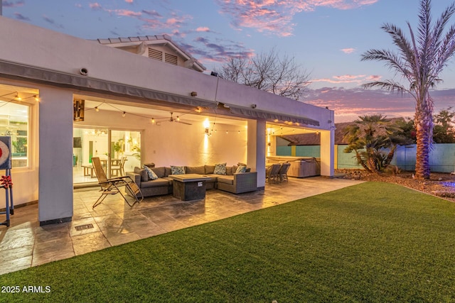 patio terrace at dusk with a lawn and an outdoor hangout area