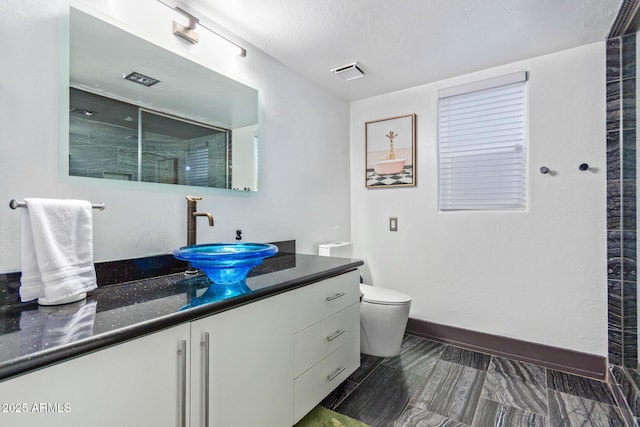 bathroom with toilet, an enclosed shower, and vanity