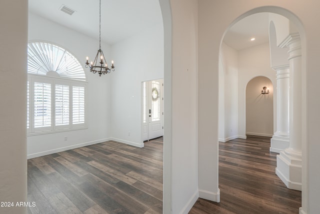 foyer with dark wood-type flooring and a notable chandelier