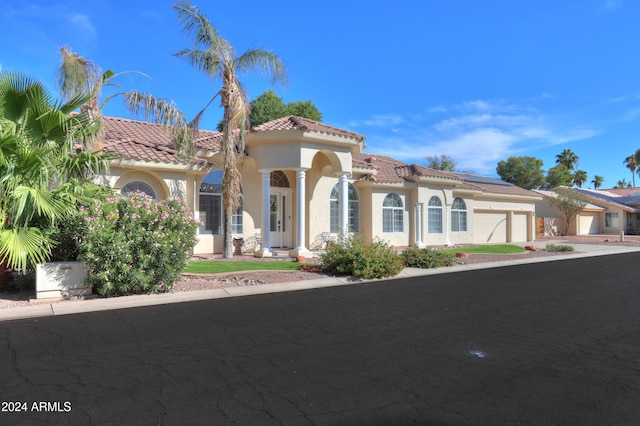 mediterranean / spanish home with a garage