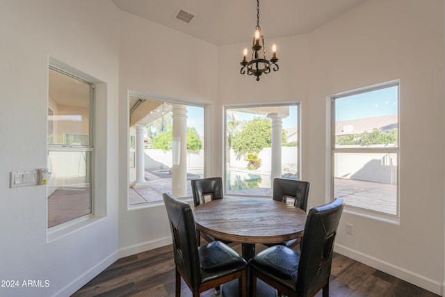 dining space with dark wood-type flooring and a chandelier