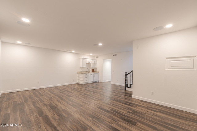 basement featuring sink and dark wood-type flooring