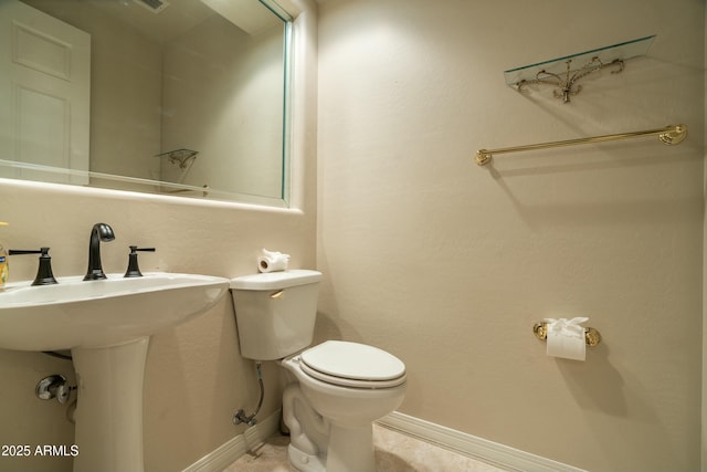 bathroom with toilet, tile patterned flooring, and sink